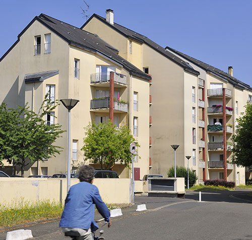 cycliste de dos devant immeuble bas 